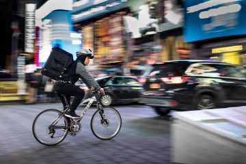 courier on a bicycle riding through the city